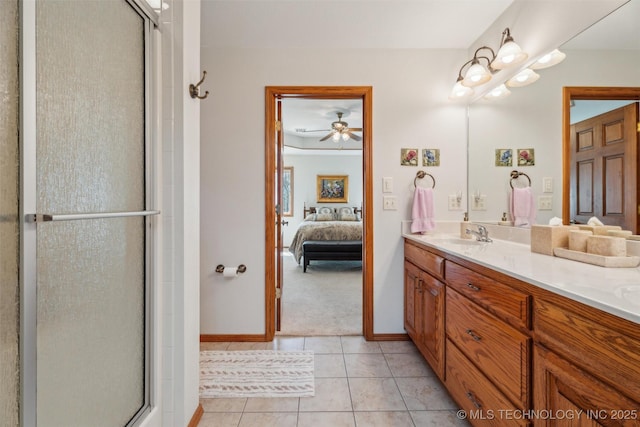 full bathroom featuring a shower with shower door, double vanity, a sink, tile patterned floors, and connected bathroom