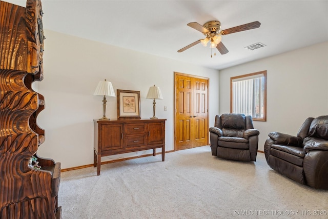 sitting room featuring light carpet, visible vents, baseboards, and a ceiling fan