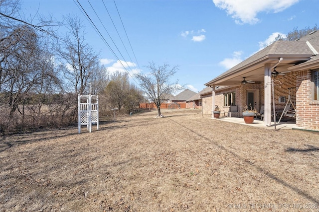 view of yard with fence, a ceiling fan, and a patio area