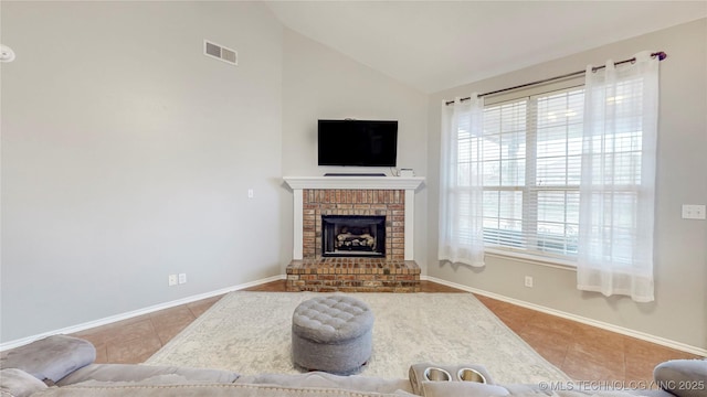 tiled living area with visible vents, a brick fireplace, baseboards, and vaulted ceiling