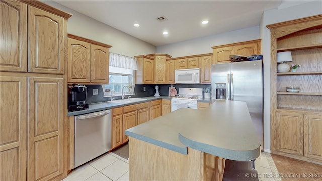 kitchen featuring a sink, a center island, recessed lighting, appliances with stainless steel finishes, and light tile patterned floors