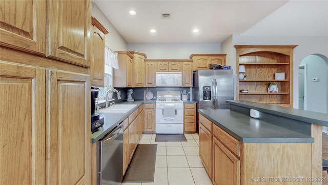 kitchen with visible vents, a sink, dark countertops, stainless steel appliances, and light tile patterned floors