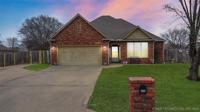 view of front of home featuring brick siding, fence, concrete driveway, a front yard, and an attached garage