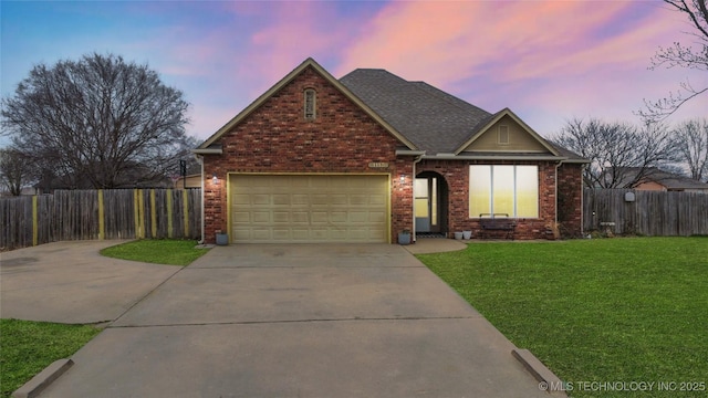 view of front facade featuring a front lawn, concrete driveway, fence, and brick siding