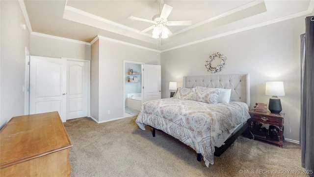 carpeted bedroom with crown molding, ensuite bath, and a raised ceiling