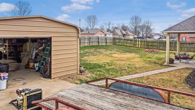 view of yard with an outdoor structure, a fenced backyard, and a patio