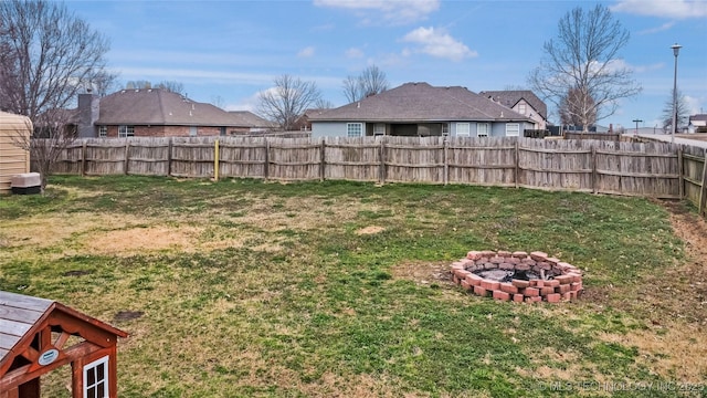 view of yard featuring an outdoor fire pit and fence