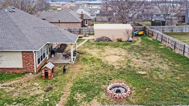 view of yard with a patio area, a residential view, a fire pit, and a fenced backyard