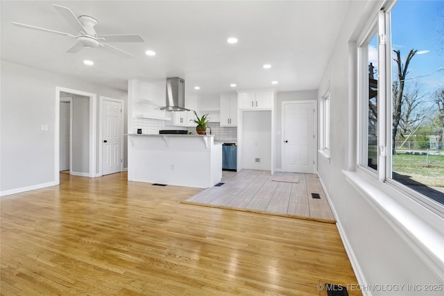 unfurnished living room with baseboards, recessed lighting, a ceiling fan, and light wood-style floors