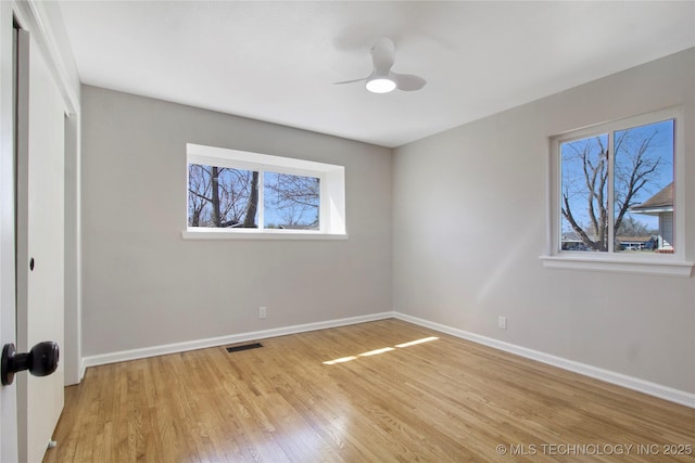 unfurnished bedroom with multiple windows, baseboards, visible vents, and light wood finished floors