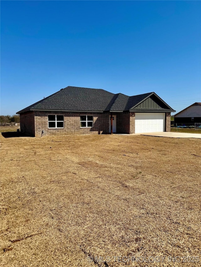 ranch-style house with a front lawn, board and batten siding, concrete driveway, an attached garage, and brick siding