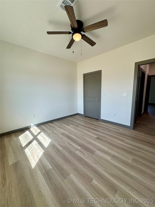 unfurnished bedroom with a ceiling fan, baseboards, visible vents, and light wood-type flooring