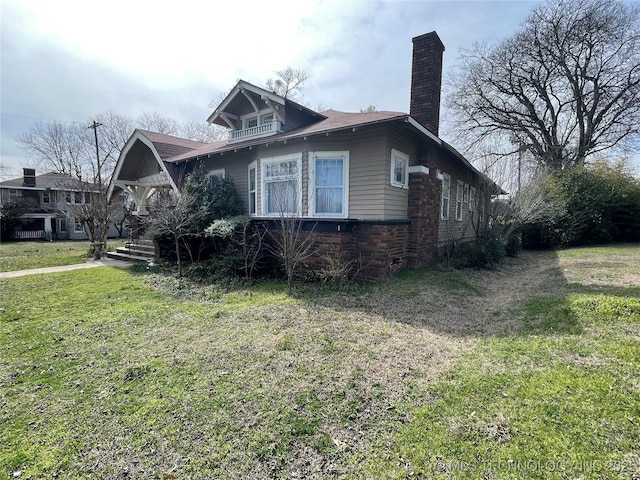 view of home's exterior with a chimney and a yard