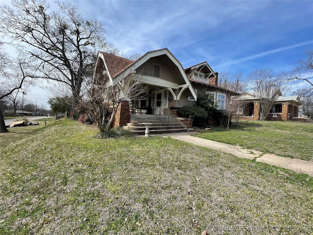 view of front facade with a gambrel roof and a front lawn