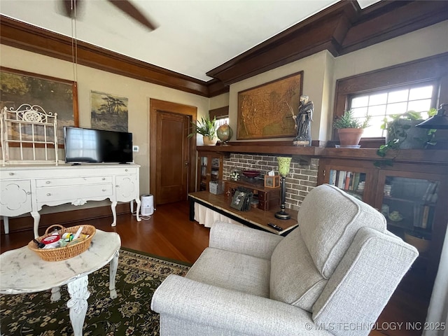 living room featuring dark wood-type flooring, ornamental molding, and a ceiling fan