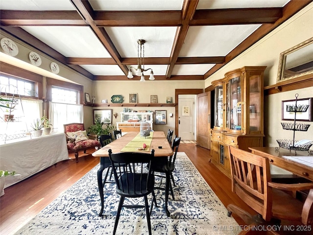 dining space with an inviting chandelier, wood finished floors, coffered ceiling, and beam ceiling