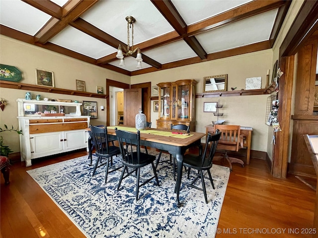 dining room with a notable chandelier, coffered ceiling, baseboards, and wood finished floors