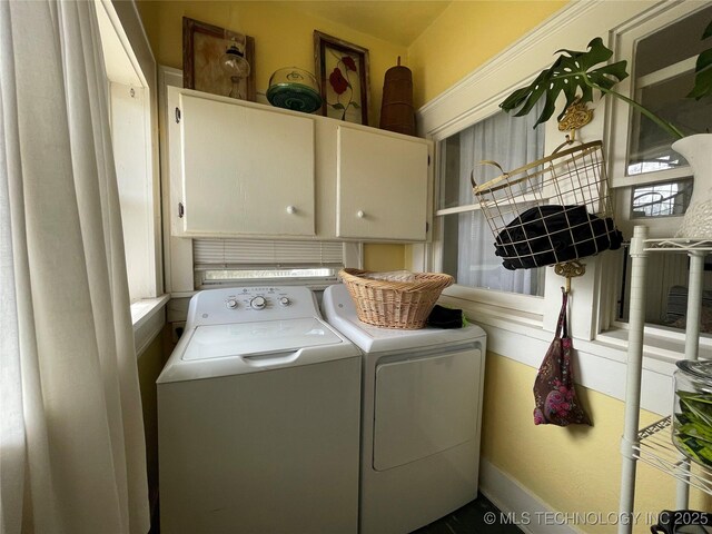 clothes washing area featuring washing machine and clothes dryer and cabinet space