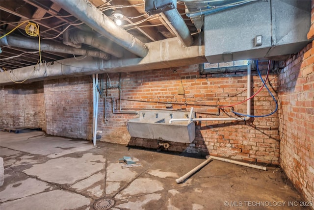unfinished below grade area with brick wall and a sink