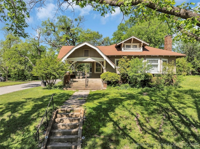 view of front of home with a chimney, a front lawn, and a porch
