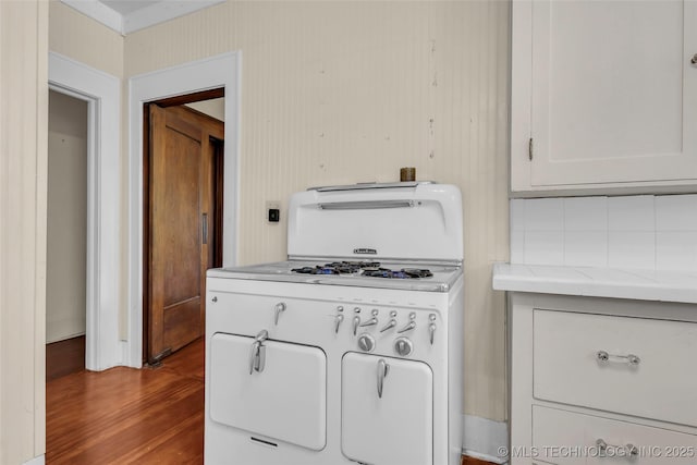 kitchen with light stone counters, wood finished floors, and white cabinetry