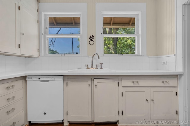 kitchen with dishwasher, decorative backsplash, a sink, and white cabinets