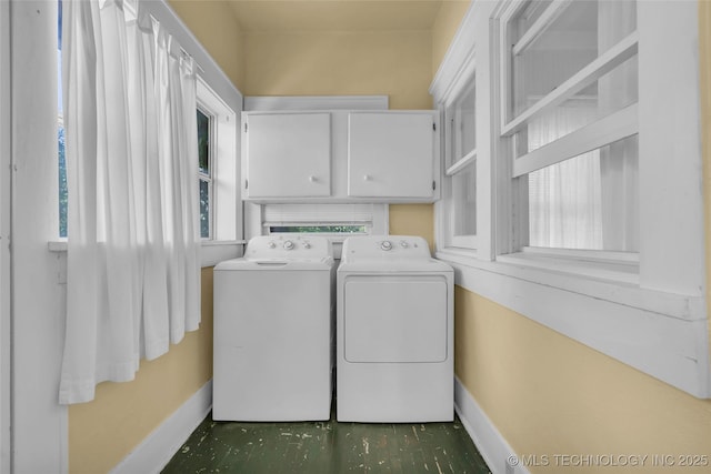 clothes washing area with cabinet space, independent washer and dryer, and baseboards