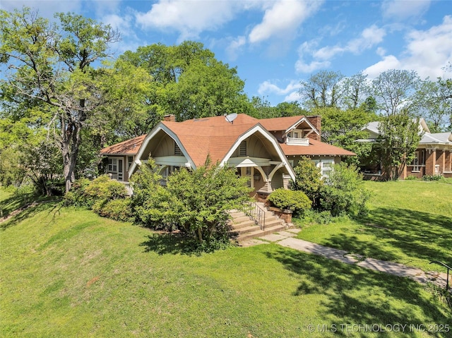 view of front of home with a chimney and a front yard