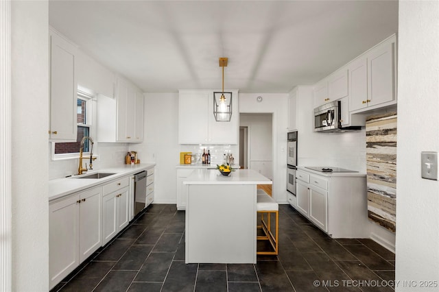 kitchen with a kitchen island, white cabinets, stainless steel appliances, and a sink