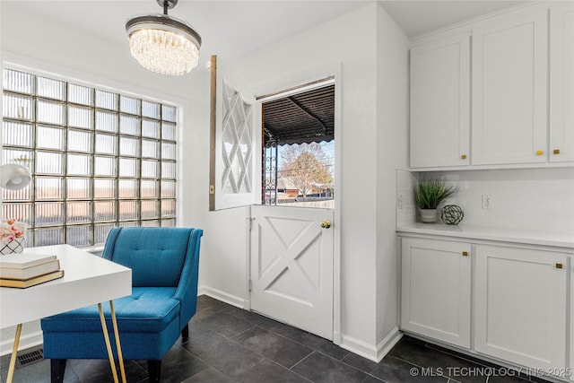 dining area featuring dark tile patterned floors, baseboards, and a chandelier