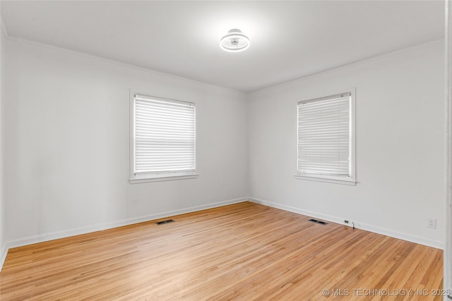 unfurnished room with visible vents, light wood-type flooring, and baseboards