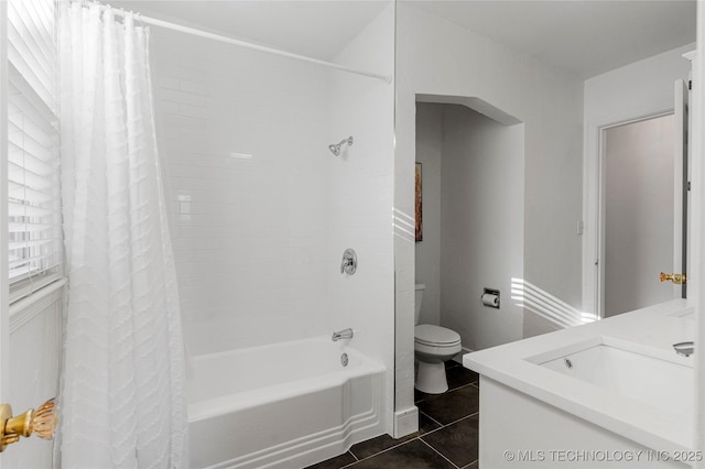 bathroom featuring tile patterned flooring, toilet, shower / bath combo, and a sink