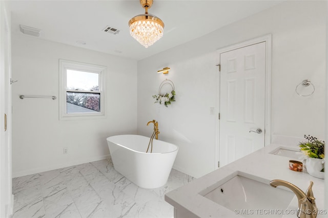 bathroom featuring visible vents, an inviting chandelier, a soaking tub, marble finish floor, and a sink