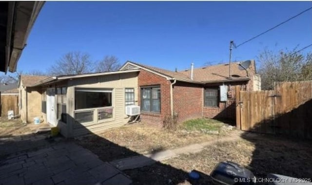 back of property featuring fence and brick siding