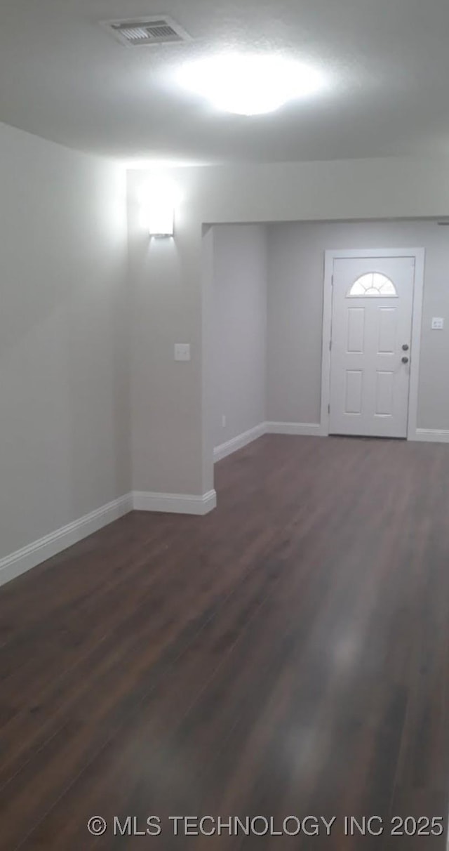 entrance foyer with dark wood finished floors, visible vents, and baseboards