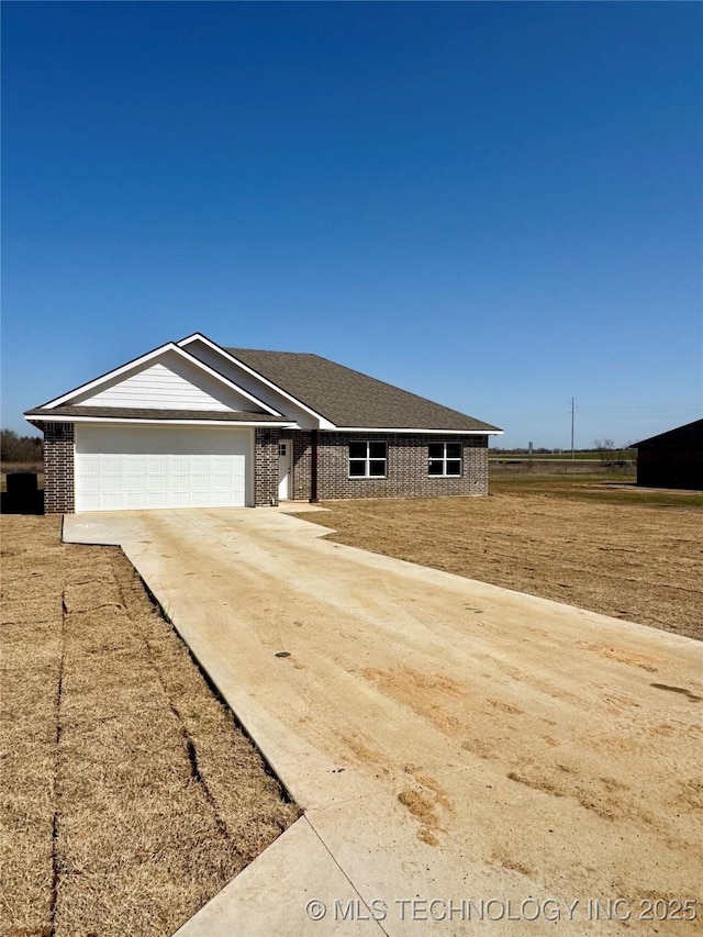 view of front of home with concrete driveway, an attached garage, and brick siding