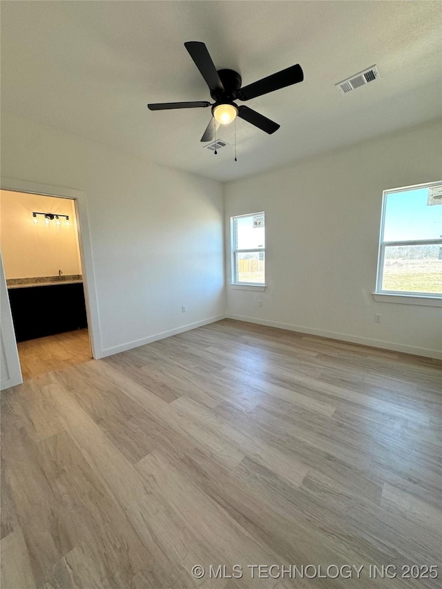 spare room with visible vents, a ceiling fan, and light wood finished floors