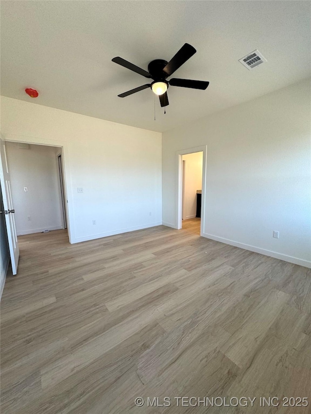 empty room with visible vents, baseboards, light wood-style flooring, and a ceiling fan