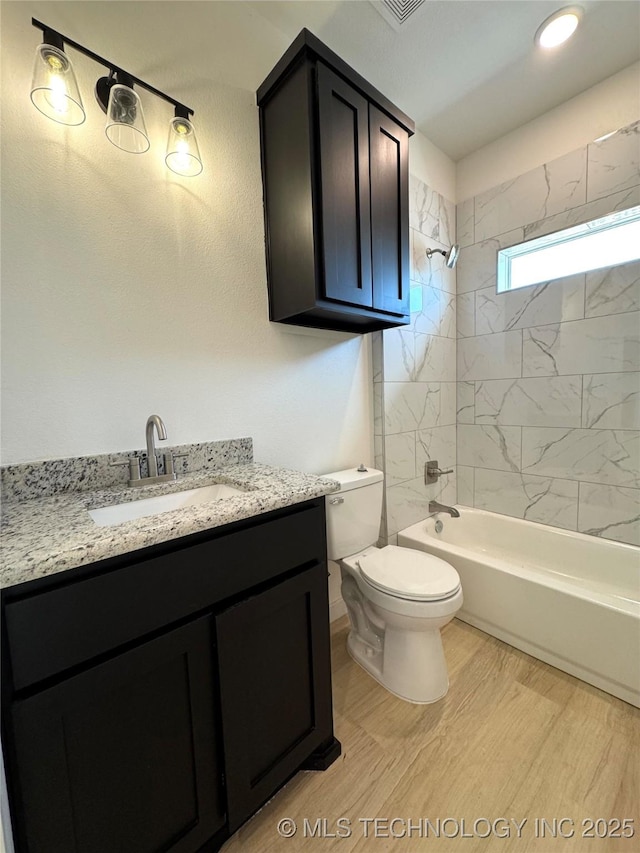 full bathroom featuring tub / shower combination, toilet, wood finished floors, and vanity