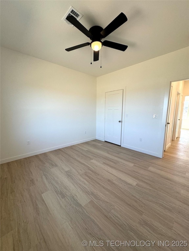 unfurnished bedroom featuring ceiling fan, baseboards, visible vents, and light wood-type flooring