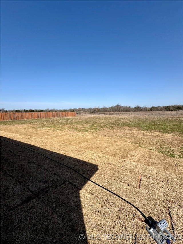 view of yard with a rural view and fence