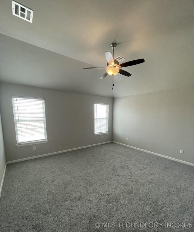 empty room featuring visible vents, carpet flooring, baseboards, and ceiling fan