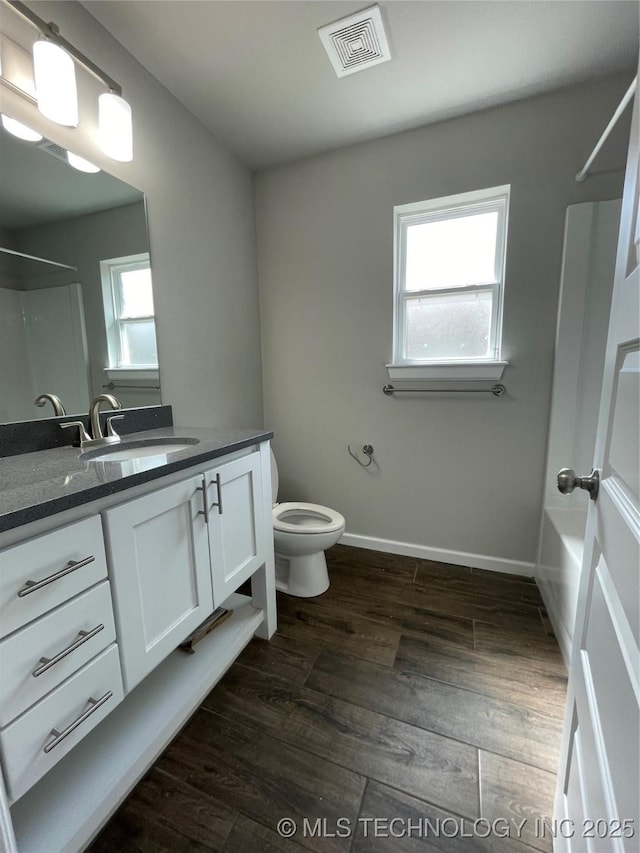 bathroom with a shower, visible vents, plenty of natural light, and wood finished floors