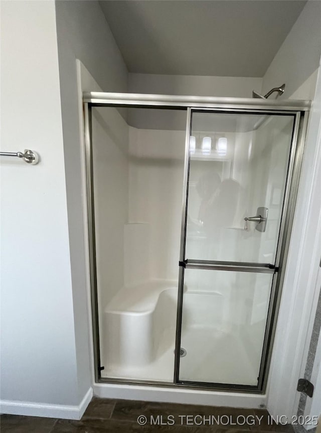 full bath with a shower stall, baseboards, and wood finished floors