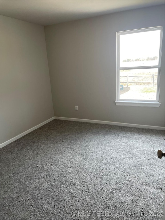 carpeted spare room featuring baseboards