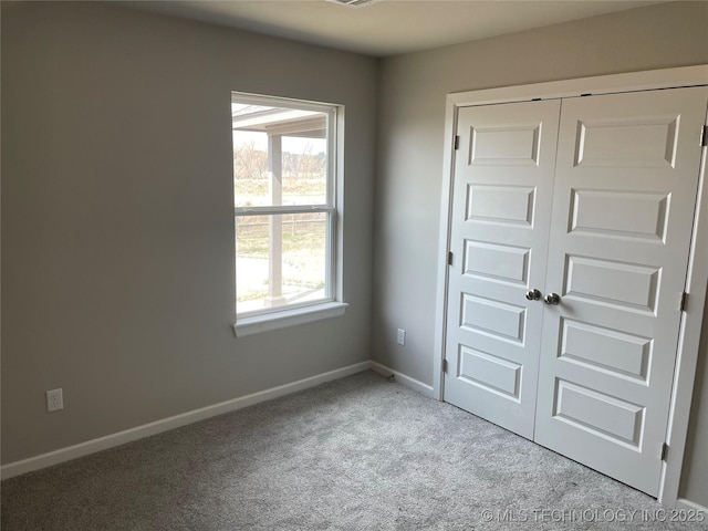 unfurnished bedroom with a closet, baseboards, and carpet floors