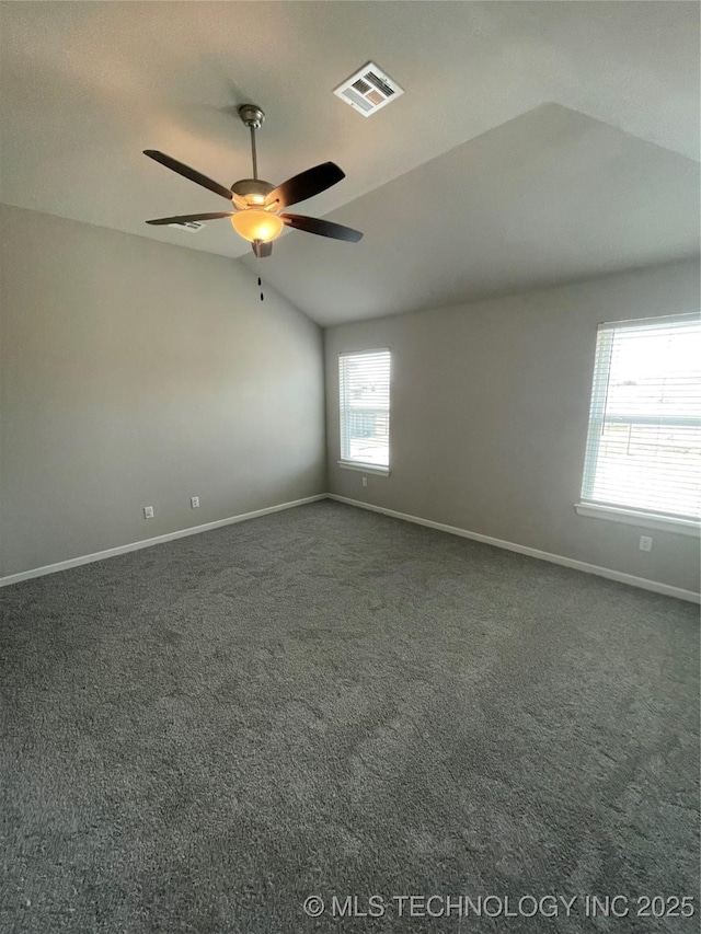 spare room featuring visible vents, ceiling fan, baseboards, dark carpet, and lofted ceiling