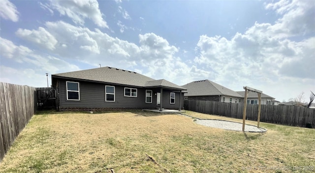 rear view of property with a yard, a fenced backyard, a patio, and roof with shingles