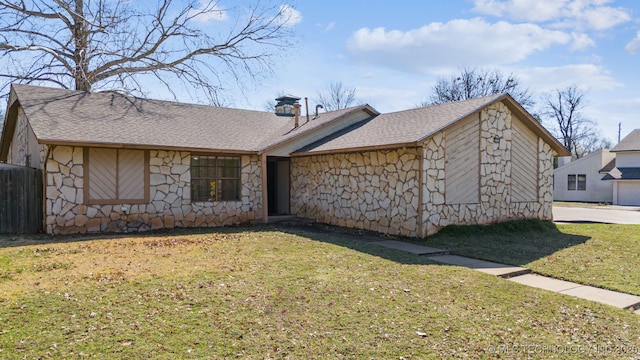 exterior space featuring a front lawn, stone siding, roof with shingles, and a chimney