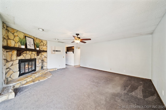 unfurnished living room featuring a stone fireplace, carpet flooring, a ceiling fan, and a textured ceiling